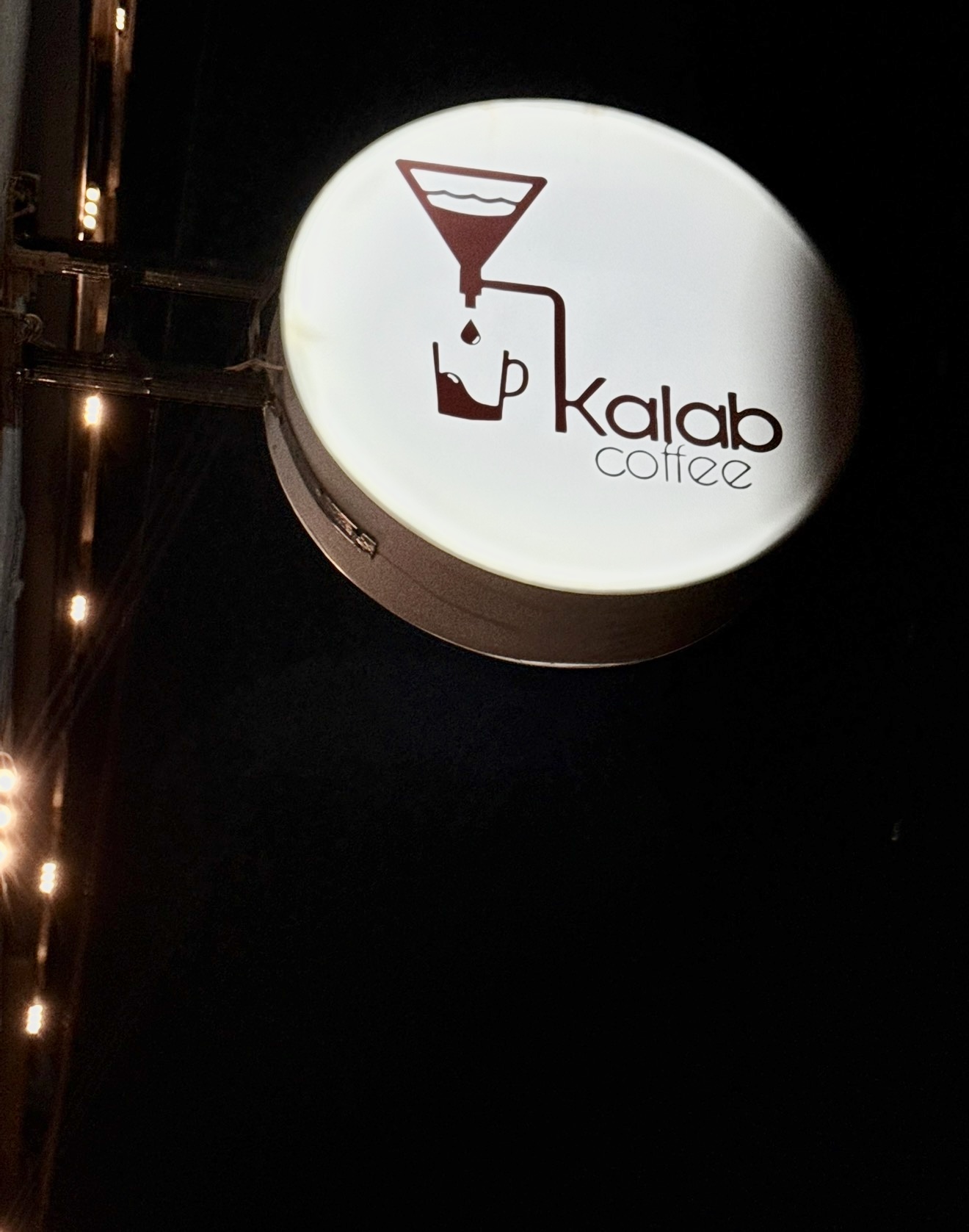 The Kalab Coffee sign glowing at night
