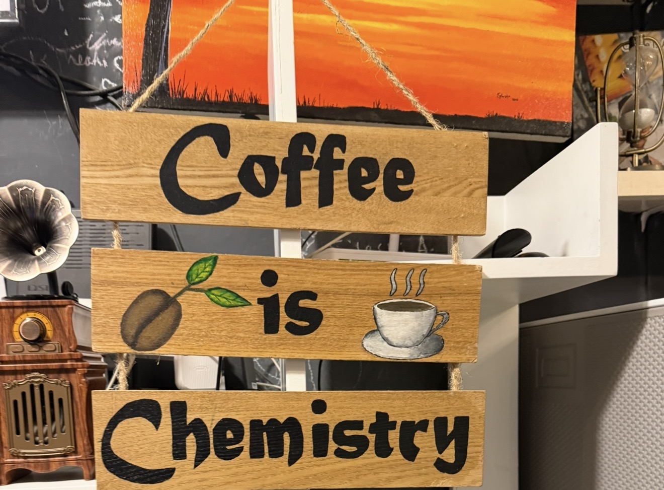 The 'Coffee is Chemistry' wooden sign hanging in the Kalab Coffee shop