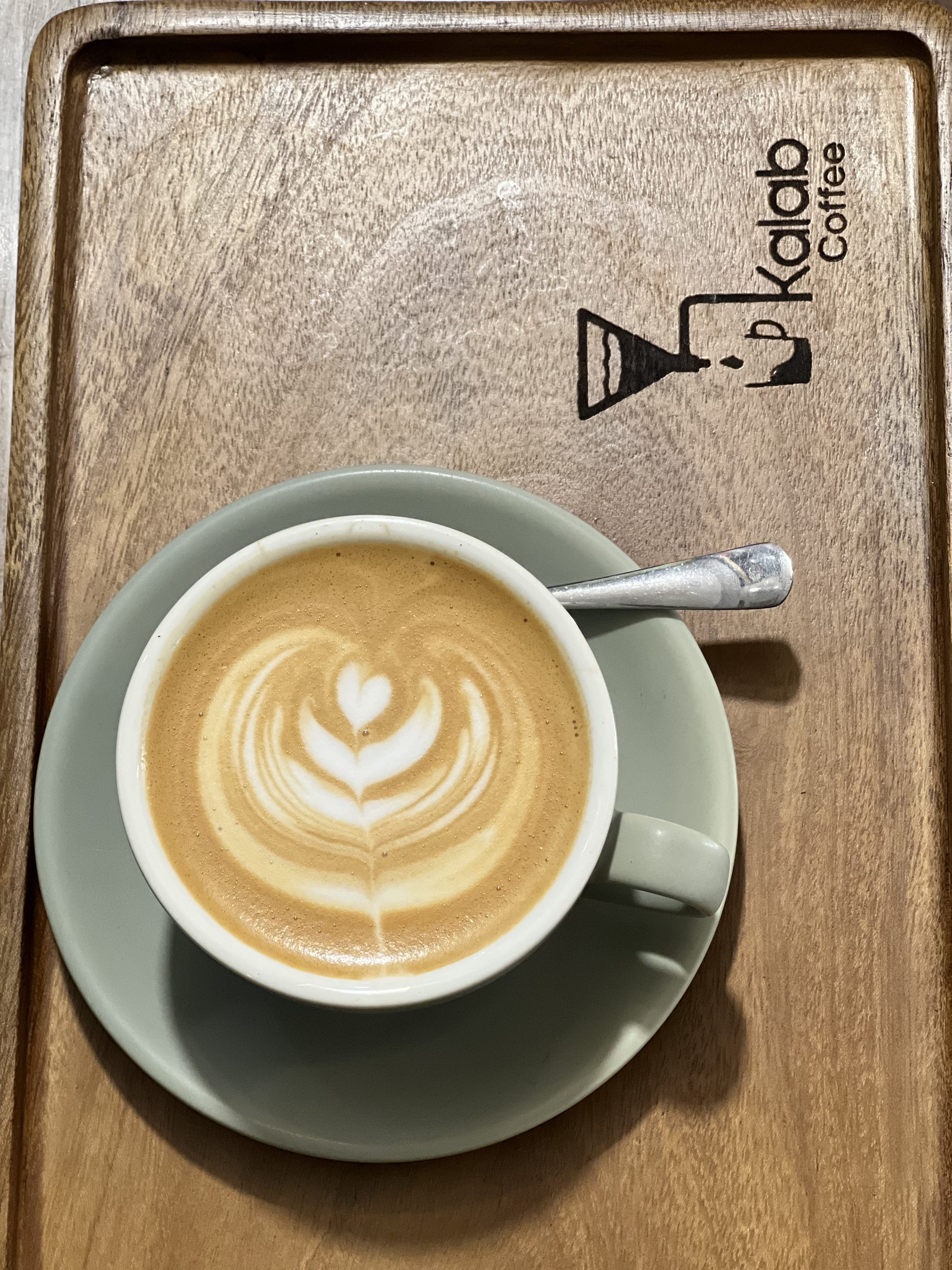 Kalab Coffee latte on a branded wooden tray